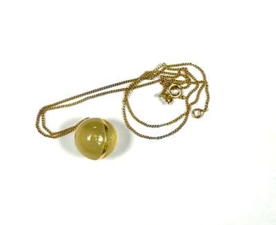a close up of a necklace with a ball on a chain