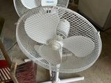 a white fan sitting on top of a metal stand