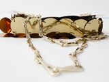 a pair of glasses and a chain on a white surface