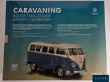 a blue and white vw bus on display in a display case