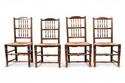 four wooden chairs are lined up against a white background