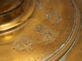 a close up of a gold vase with a black background