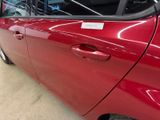 a red car that has a sticker on the side of it