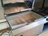 two stainless steel stoves in a kitchen with white tile flooring