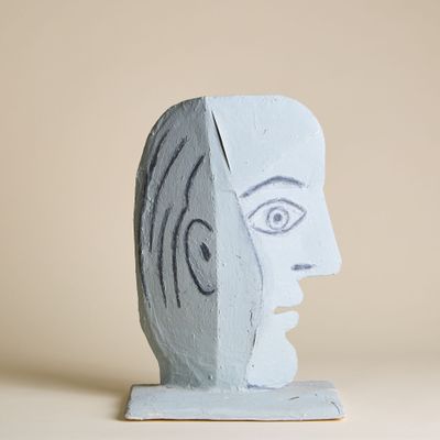 une sculpture représentant le visage d'un homme, posée sur un socle