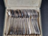a lot of silver spoons in a box on the table