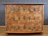 an old wooden chest of drawers with brass handles on a wooden floor