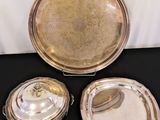 two silverplated trays with lids and lids on a black table