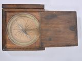 a small wooden box with a compass on top of it