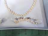 a picture of a necklace and pair of scissors in a box