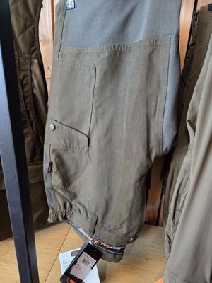 clothing hanging on a rack in a clothing store next to a pair of shoes