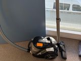 un aspirateur posé par terre près d'une fenêtre