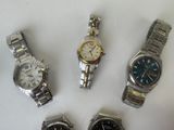 several watches are lined up in a row on a white surface