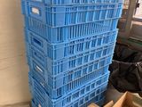 une pile de caisses bleues posées par terre près d'une fenêtre