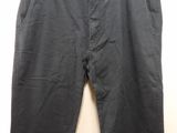 a pair of black pants hanging on a hanger on a wall