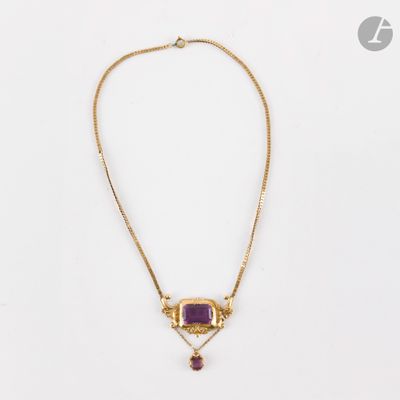 un collier en or orné d'une pierre violette et d'une chaîne en or