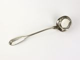 une cuillère en argent avec un manche de cuillère sur une surface blanche