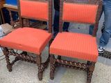 two men standing next to each other near a set of chairs
