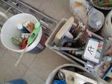 several buckets filled with assorted items sitting on a tiled floor