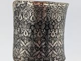 a close up of a silver cuff with a cross on it