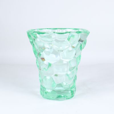 un vase en verre vert posé sur une table
