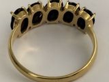an image of a gold ring with black stones on it