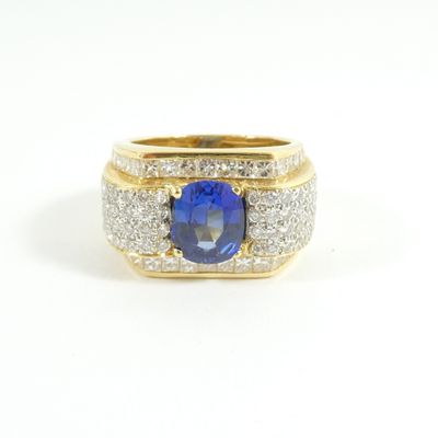 a close up of a blue sapphire and diamond ring on a white background