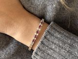 a close up of a woman ' s hand wearing a red and white bracelet