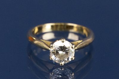 un gros plan d'une bague en diamant posée sur une surface bleue