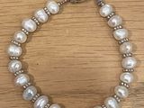 un gros plan d'un bracelet orné de perles posé sur une table en bois