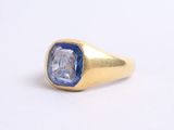 a close up of a gold ring with a blue sapphire stone