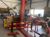 une photo d'un homme en train de travailler sur un véhicule dans un garage