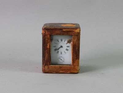 a small wooden clock with a white face on a table