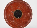 un gros plan d'une assiette rouge et noire posée sur une surface blanche