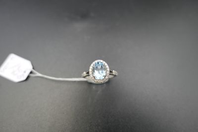 a close up of a white gold ring with a blue topaz stone