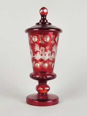 une image représentant un vase en verre rouge orné d'une scène de Noël
