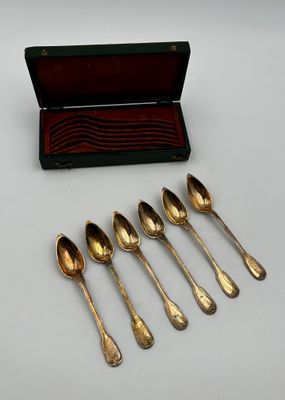six spoons and a box of silverware on a white surface
