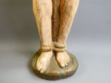 une statue en bois représentant un homme avec une cravate autour de la taille