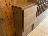 someone is writing on the wall next to a wooden cabinet