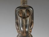 an image of a wooden statue of a man sitting on a stool