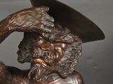 bronze statue of a man with a hat on his head