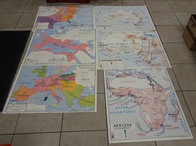 several maps of europe on a tiled floor in a room