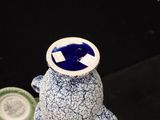 a blue and white vase with a bear on top of it
