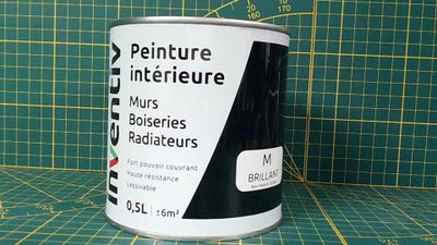 un pot de peinture posé sur un tapis de découpe