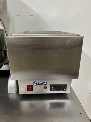 une photo d'une friteuse professionnelle posée sur un plan de travail en inox