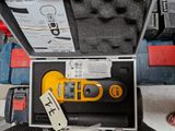 un outil jaune et noir dans un coffret posé par terre
