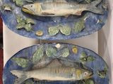 two plates with fish on them sitting on a table