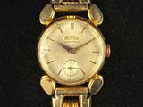 an image of a close up of a gold watch on a black surface