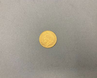 une pièce d'or sur une surface grise