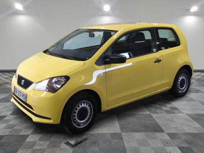 La petite voiture jaune est garée sur un sol en damier.